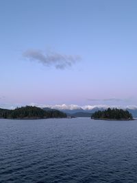 Scenic view of sea against clear sky with snowy peaks and green lucious islands