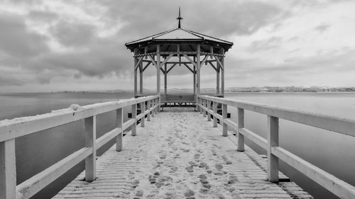 Pier on beach against sky
