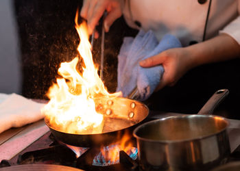 Midsection of man preparing food on barbecue grill