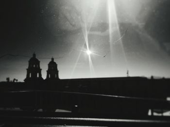 Silhouette man against illuminated sky at night