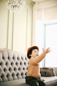 Boy sitting on sofa at home