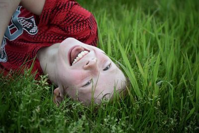 Close-up of boy lying on grassy field