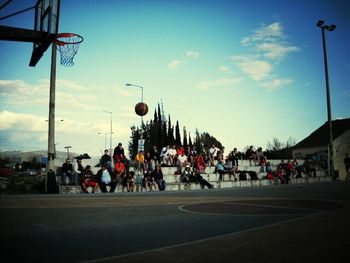 People on road against cloudy sky