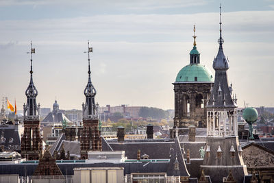 Royal palace of amsterdamamidst buildings against sky