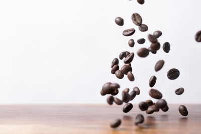 Close-up of coffee beans on table against white background