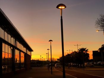 Street lights against sky during sunset