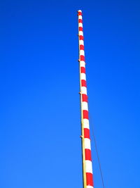 Low angle view of crane against clear blue sky