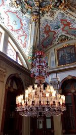 Low angle view of illuminated chandelier hanging in building