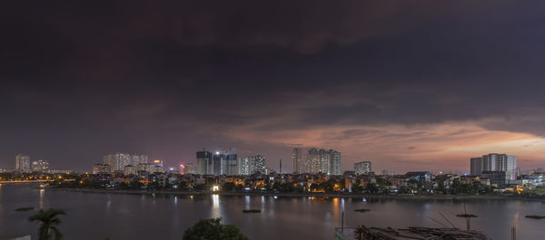 Illuminated buildings in city against sky at night