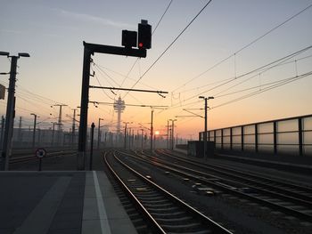 Railroad station platform against sky during sunset