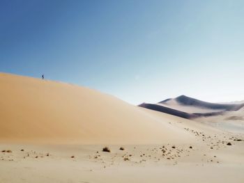 Scenic view of desert against clear blue sky