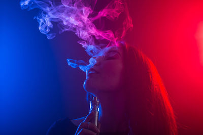 Portrait of young woman smoking cigarette