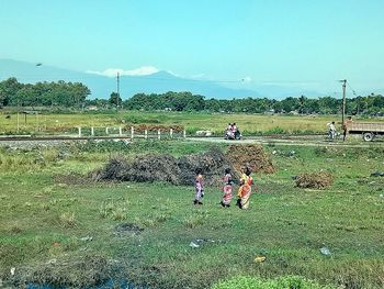 People working on field against sky