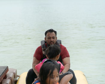 Cheerful family sitting on boat in lake