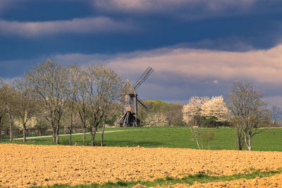 Traditional windmill on field against sky