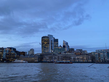 View across river thames to city of london at dusk