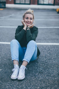 Portrait of smiling young woman sitting outdoors