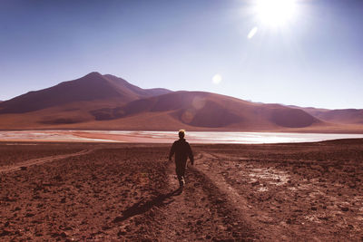 Man walking on mountain against sky