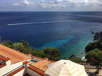 High angle view of houses by sea against sky