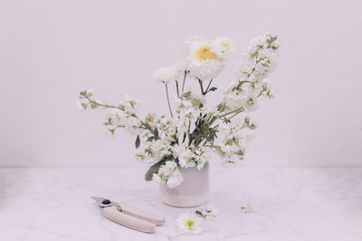 Wide shot of chrysanthemum and aleli flowers against wall