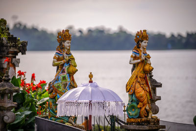 Close-up of statue by sea against sky