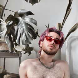 Low angle view of young man wearing sunglasses against plants