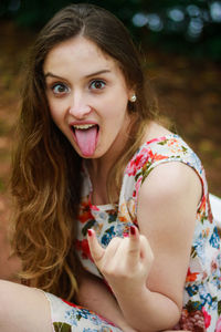 Close-up portrait of woman sticking out tongue