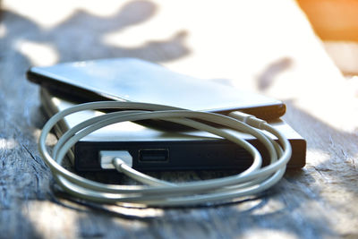 Close-up of mobile phone connected to portable charger on table