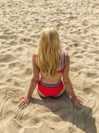 Rear view of woman sitting at beach