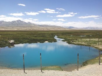 Scenic view of lake by mountains against sky