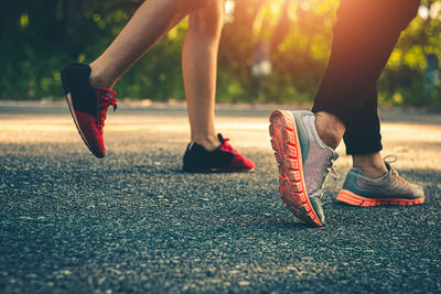 Low section of women walking on road