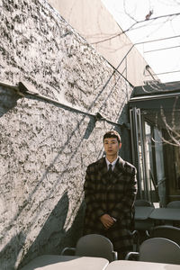 Portrait of man standing against wall