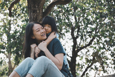 Portrait of mother and daughter against trees