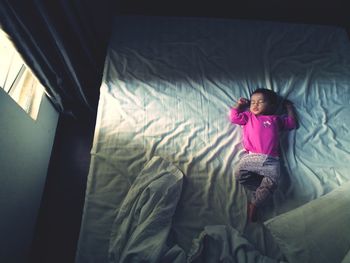 High angle view of baby girl sleeping on bed at home