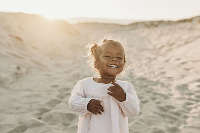 Portrait of adorable young girl at beach during sunset