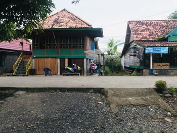 People on street by buildings against sky