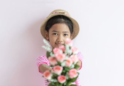 Portrait of girl with pink flowers against white background