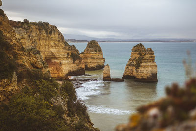 Rock formations by sea against sky