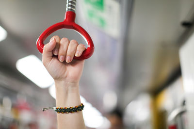 Close-up of woman holding handle in subway train