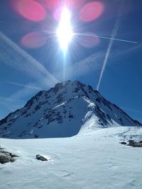 Scenic view of snowcapped mountains against sky on sunny day