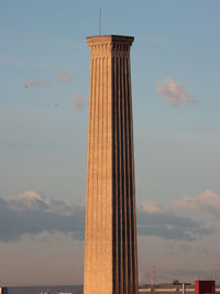Low angle view of tower against cloudy sky