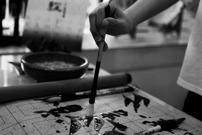 Close-up of person hand painting over paper on table