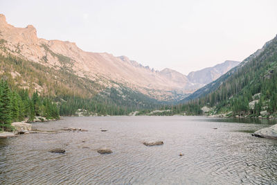 Scenic view of lake by mountains against sky