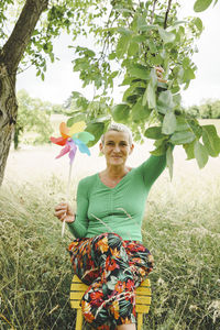 Portrait of young woman standing against plants