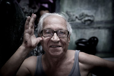 Portrait of happy senior man with cigarette at home