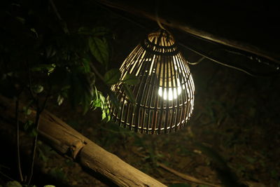 Low angle view of illuminated pendant light hanging from roof beam