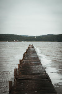 Pier over lake against sky