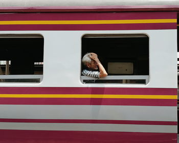 Portrait of man standing by train window