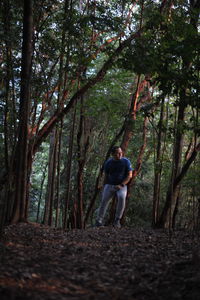 Man walking amidst trees in forest