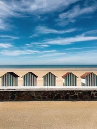 Beach houses on sand against sky